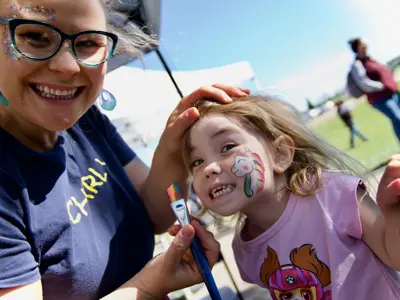 smiling young girl with excited female face painter