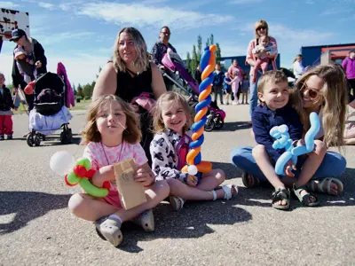 happy young children enjoying outdoor festival with their moms